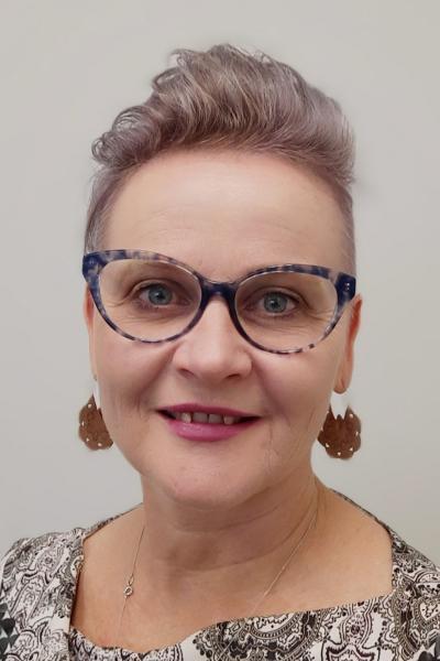 Magdel Hammond is wearing glasses with a colourful frame, and has a short hairstyle.
